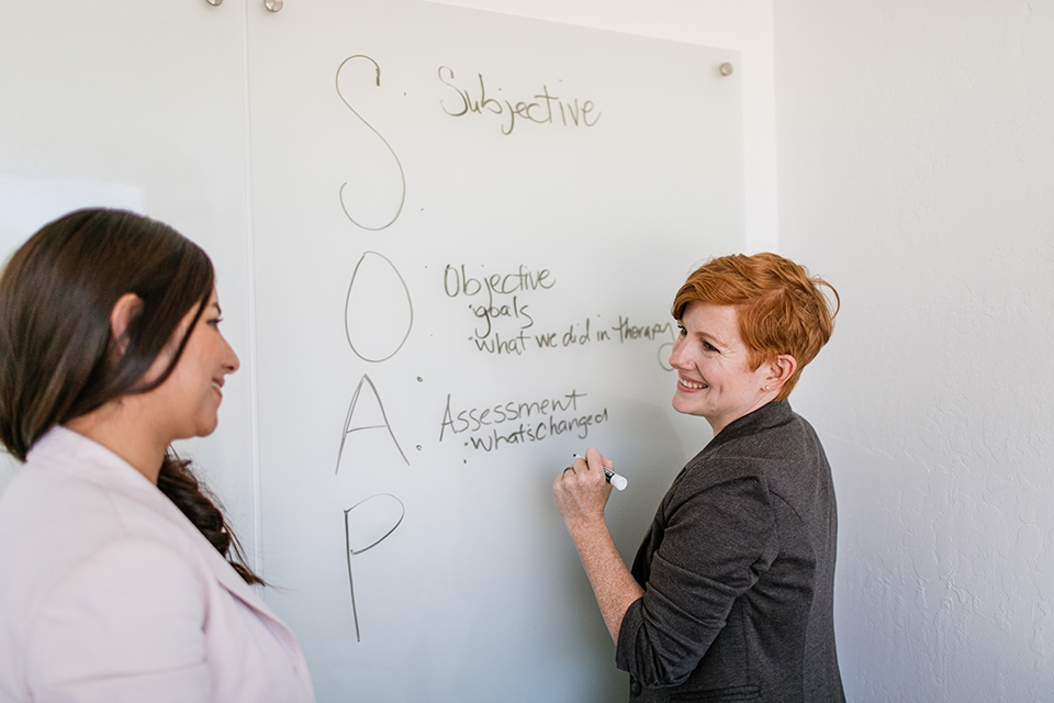 ONE Home We Are One Two women at whiteboard