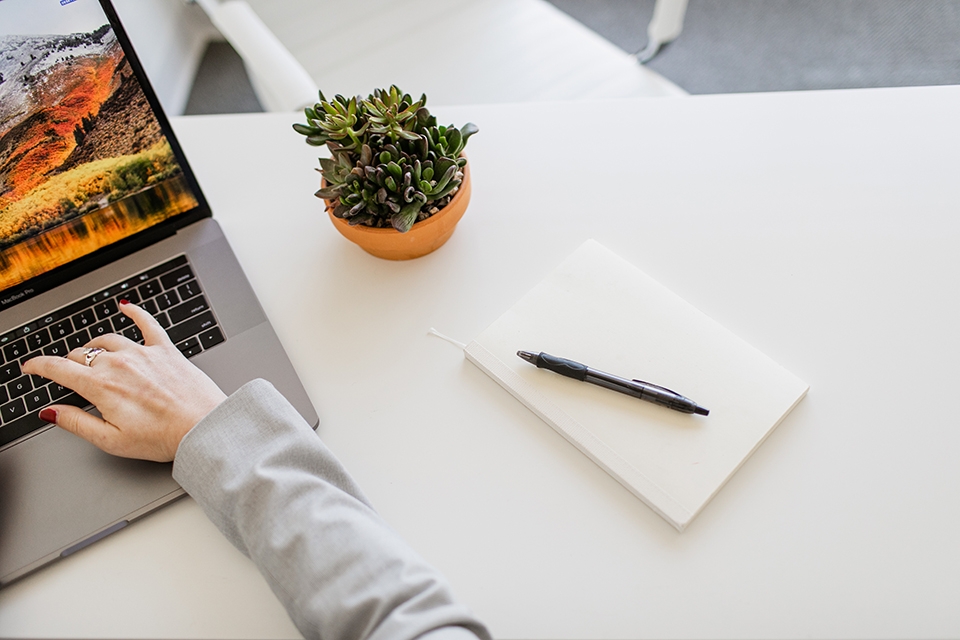 ONE Member Benefits banner Woman on laptop with notebook